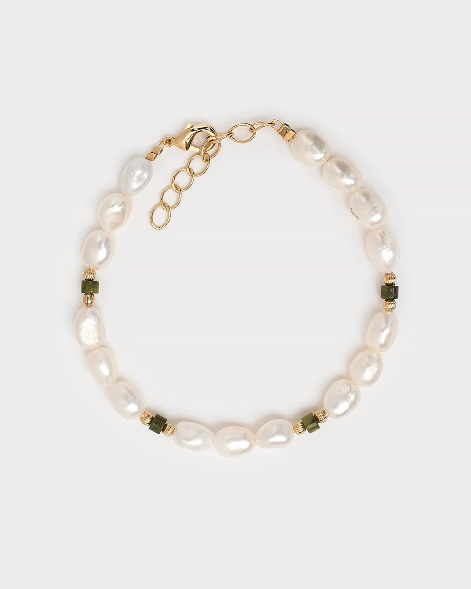 Bracelet Taranga présenté à plat sur fond blanc, mêlant harmonieusement perles d'eau douce, jade vert profond et éléments en laiton doré pour un rendu raffiné et lumineux.