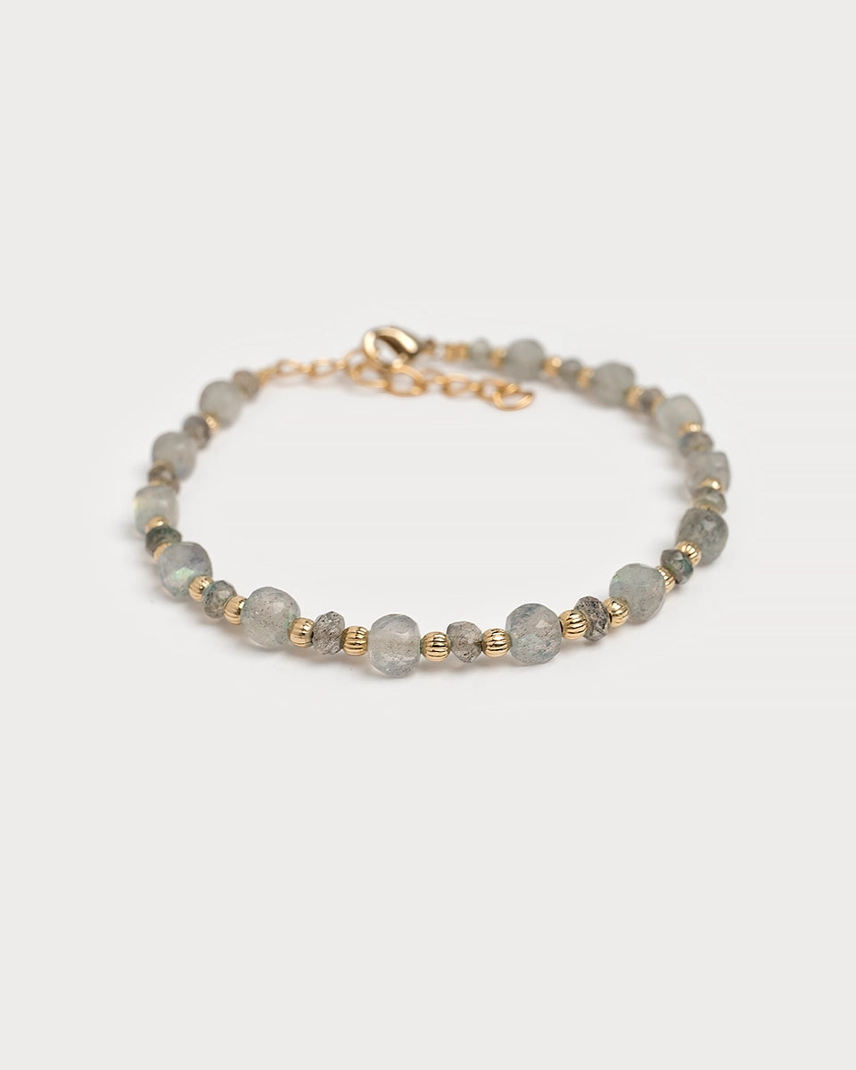 Bracelet Minali en pierres de labradorite naturelle et perles dorées, présenté en perspective sur fond clair, création artisanale française.