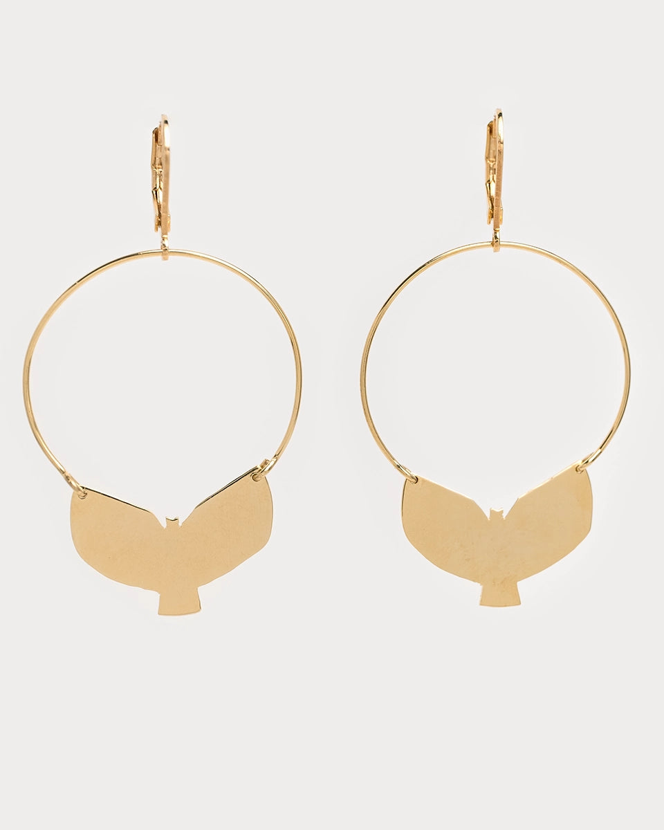 Boucles d’oreilles Udaan en laiton doré à l’or fin, créoles légères avec pendentif représentant un oiseau stylisé découpé à la main, sur fond blanc.