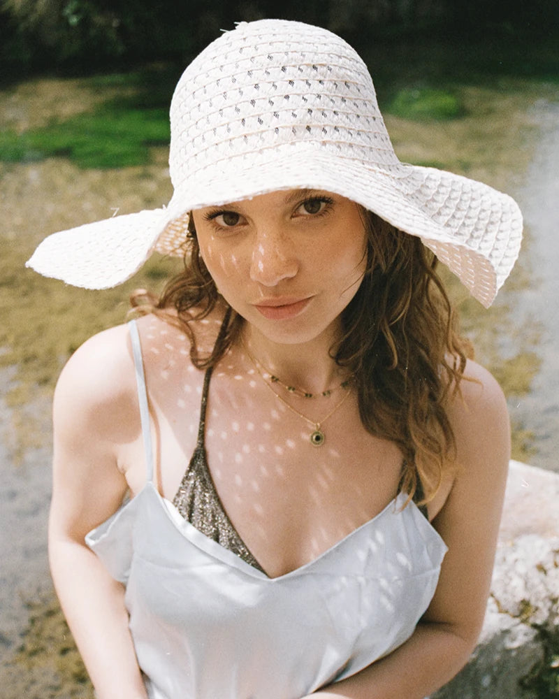 Le collier Gatika porté en situation estivale : bijou doré avec onyx, style raffiné et harmonieux signé Gauhart.