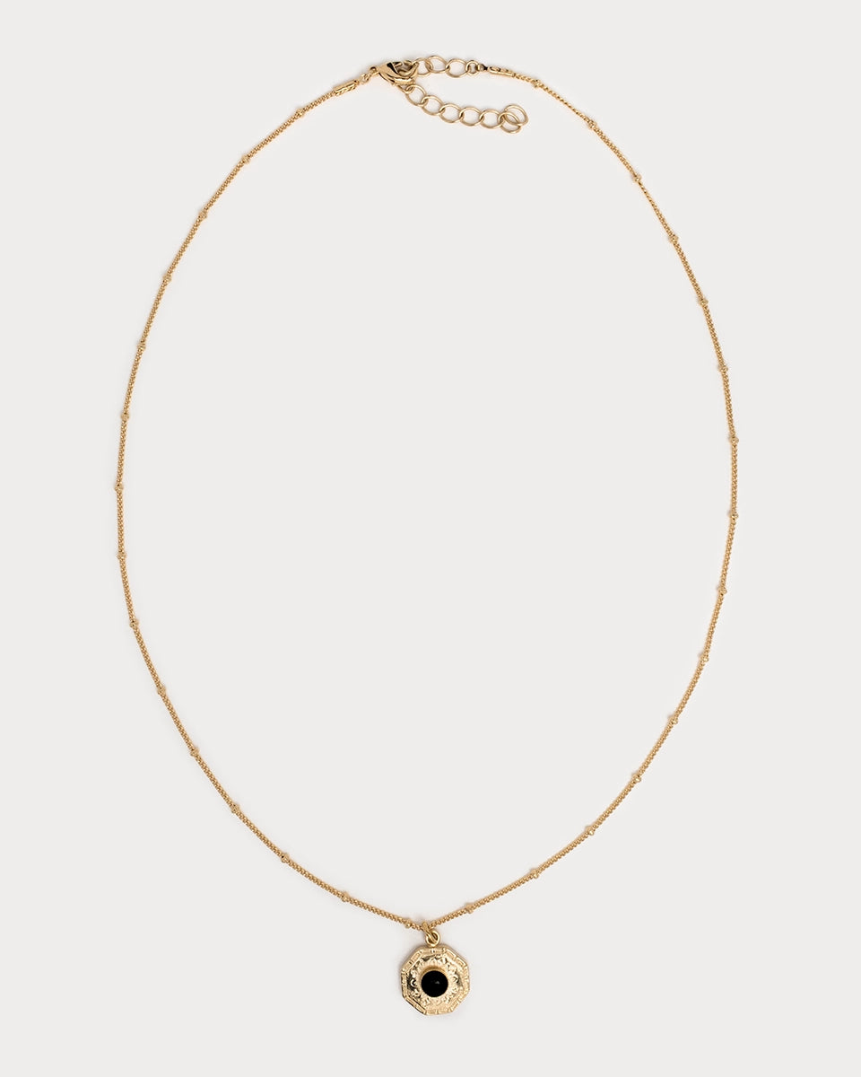 Collier Gatika en laiton plaqué or, orné d’un pendentif octogonal gravé et cabochon central en onyx noir.