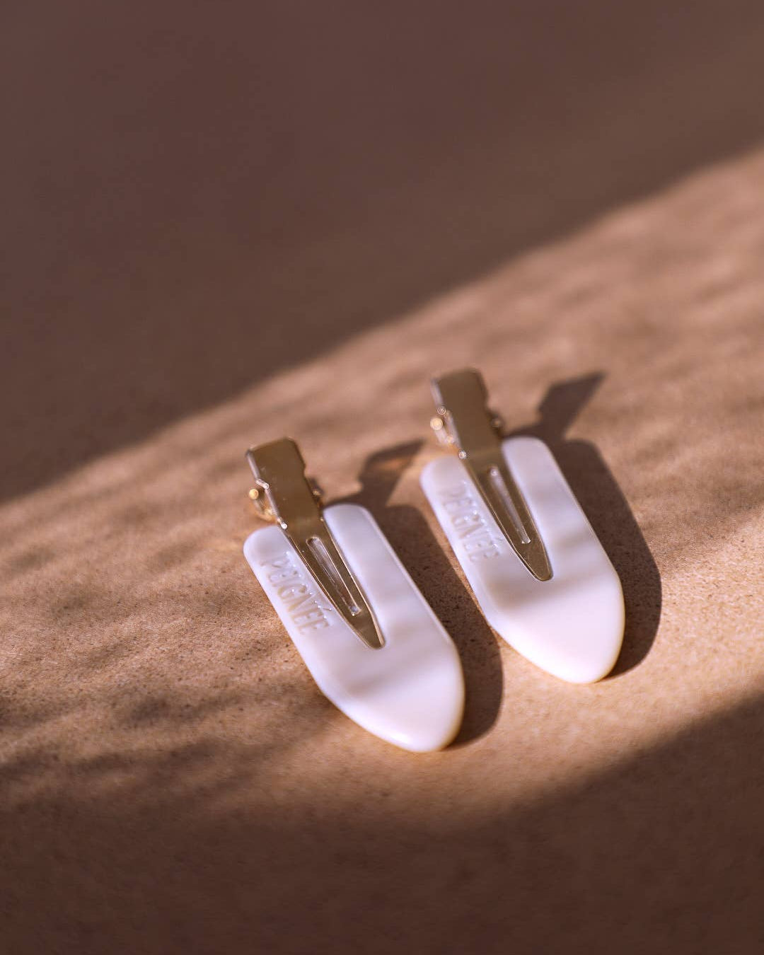 photo des Barettes à maquillage beiges aux reflets nacrés prise avec un jeu de lumière