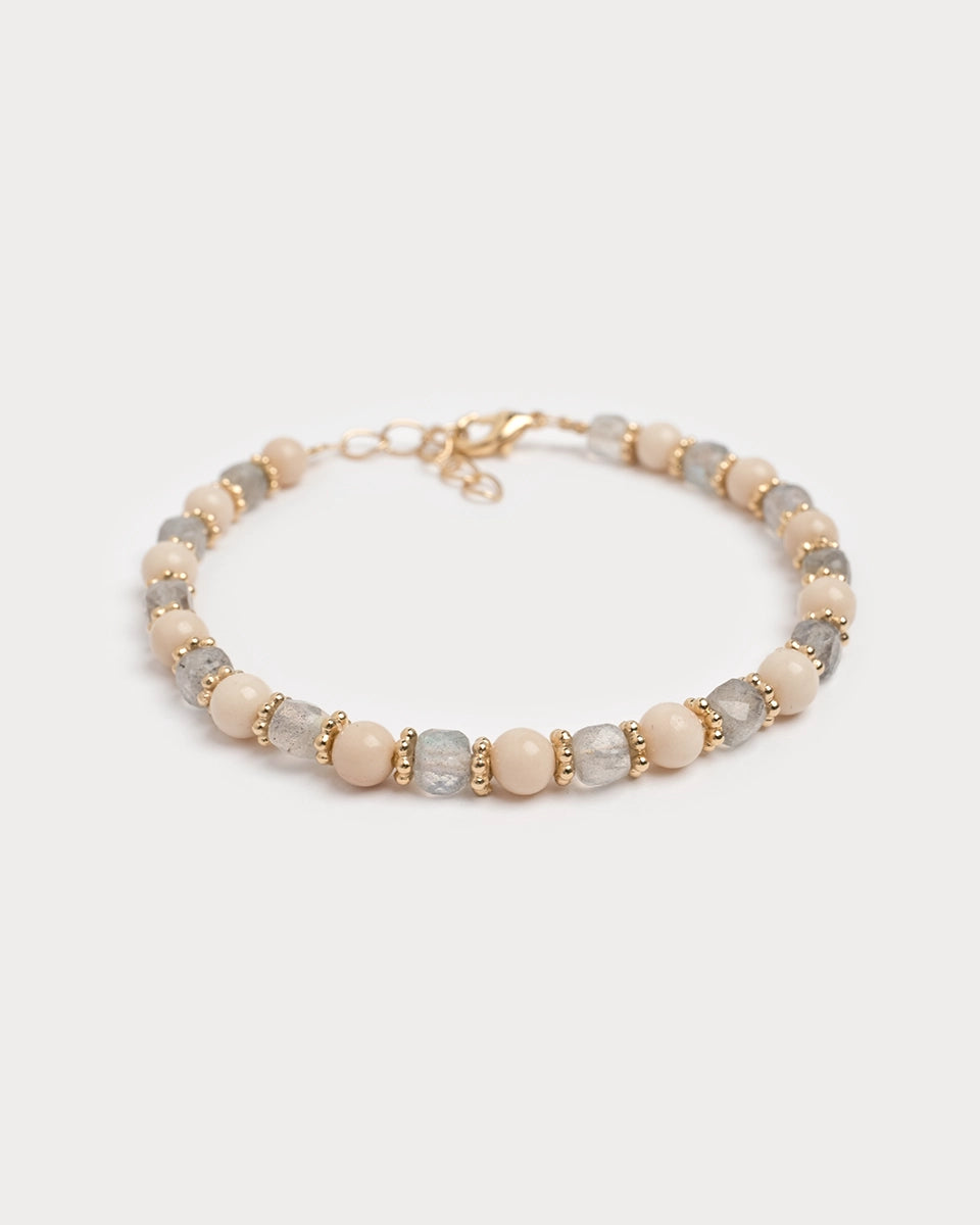 Bracelet Lavani photographié sur fond blanc, composé de perles de labradorite brute, de perles beige lisses et de petites intercalaires dorées, monté sur fermoir doré à la main dans l’atelier Gauhart.