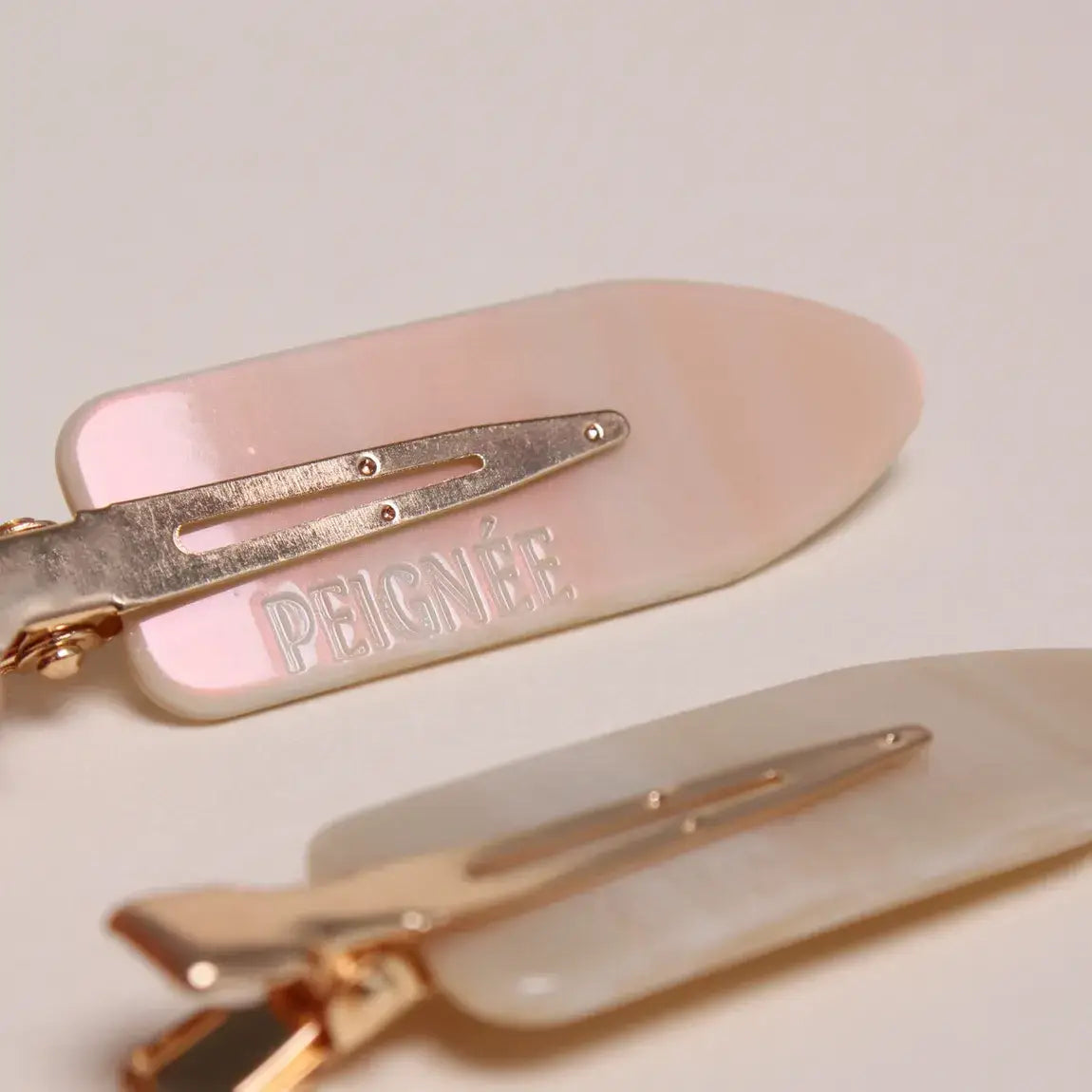 photo en gros plan d'une paire de barrettes à maquillage beiges avec des reflets nacrés